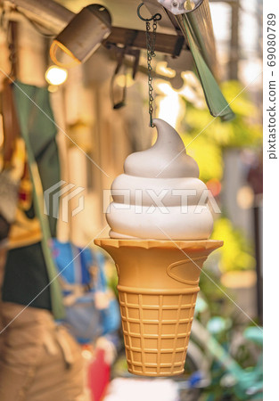 Large plastic vanilla ice cream cone hanging in front of the store Large plastic vanilla ice cream cone hanging in front of the store 69080789