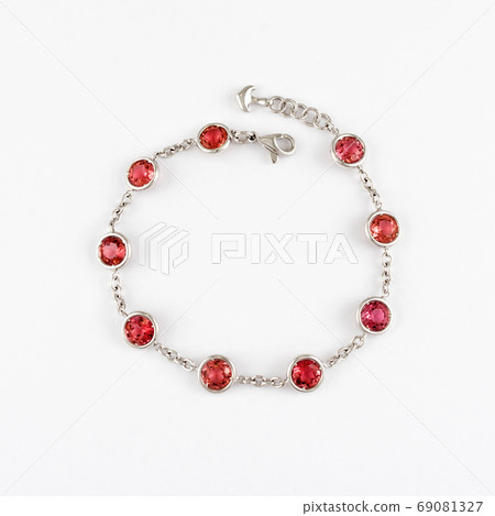 White gold or silver bracelet with red ruby gemstone on light background. White gold or silver bracelet with red ruby gemstone on light background. 69081327