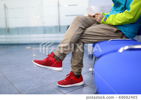 Man in sportswear is waiting on chair in hallway Man in sportswear is waiting on chair in hallway 69082405