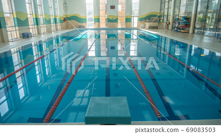 Swimming pool for athletes sports swimming indoor water, daytime shooting water glistens from the sun Swimming pool for athletes sports swimming indoor water, daytime shooting water glistens from the sun 69083503