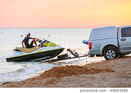 towing a jet ski to the shore 69083896