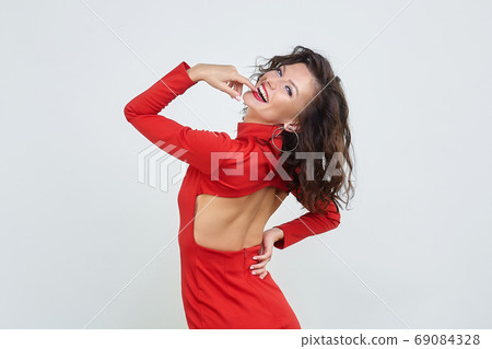 attractive girl in a red dress. photo session in the Studio on a white background attractive girl in a red dress. photo session in the Studio on a white background 69084328