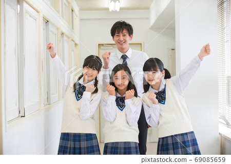 一個微笑的女初中學生和一個膽量姿勢的老師 69085659