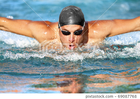 Swimmer man swimming butterfly strokes in pool Swimmer man swimming butterfly strokes in pool 69087768