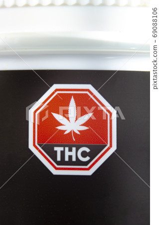 Calgary, Alberta, Canada. Sep 02, 2020. Macro close up of the Standardized Cannabis Symbol on black cannabis container. Calgary, Alberta, Canada. Sep 02, 2020. Macro close up of the Standardized Cannabis Symbol on black cannabis container. 69088106