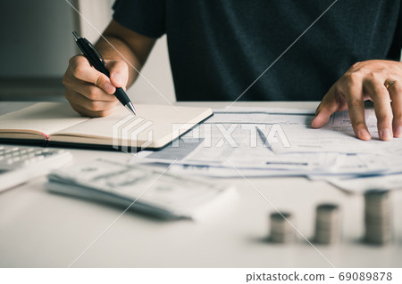 Man use calculators and documents that calculate expenses in the Man use calculators and documents that calculate expenses in the 69089878