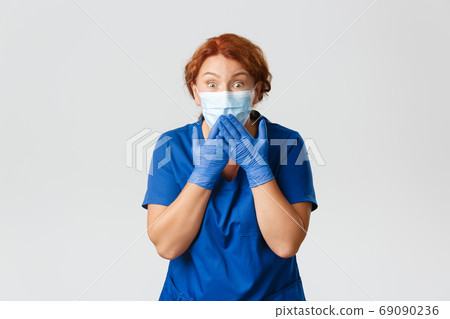 Medical workers, covid-19 pandemic, coronavirus concept. Surprised and impressed middle-aged female nurse, doctor in face mask and rubber gloves, gasping looking with amazement at camera Medical workers, covid-19 pandemic, coronavirus concept. Surprised and impressed middle-aged female nurse, doctor in face mask and rubber gloves, gasping looking with amazement at camera 69090236