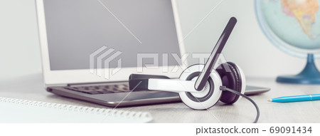 Laptop with headphones on white desk Laptop with headphones on white desk 69091434