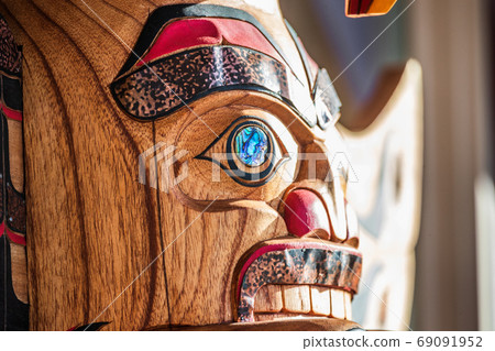 Totem sculpture art on wood pole in Alaska. Totem sculpture art on wood pole in Alaska. 69091952