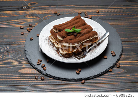Classic tiramisu dessert on ceramic plate on wooden background 69092253