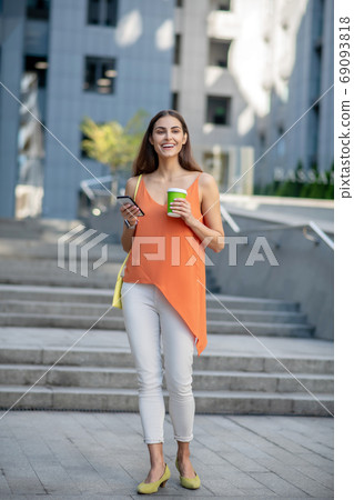 Smiling woman holding a coffee cup looking beautiful 69093818