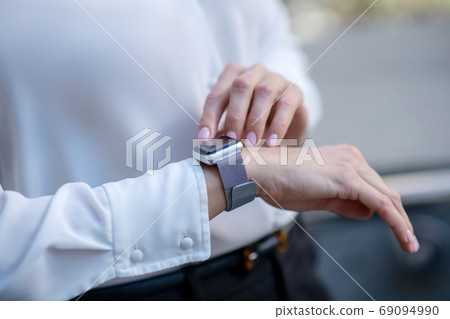 Close up picture of a woman touching a smartwatch 69094990