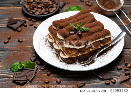 Classic tiramisu dessert on ceramic plate on wooden background Classic tiramisu dessert on ceramic plate on wooden background 69095880