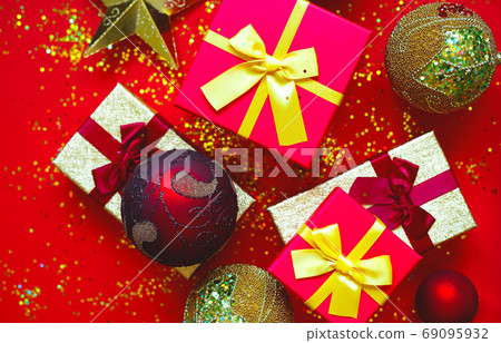 gift boxes with bows and Christmas toys on a red-gold background gift boxes with bows and Christmas toys on a red-gold background 69095932