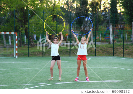 two girls go in for sports on the playground two girls go in for sports on the playground 69098122