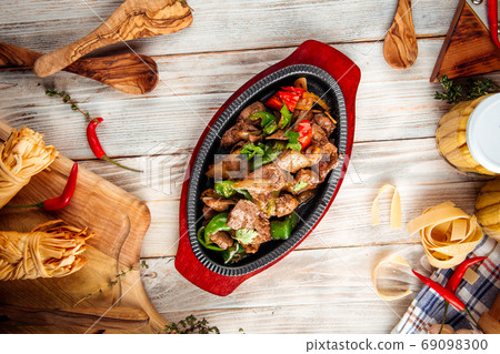 Roasted meat with vegetables in cast iron pan Roasted meat with vegetables in cast iron pan 69098300