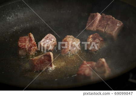 Dice steak being cooked 69099847