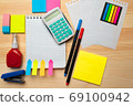 The top view of creative desk with office accessories, notebooks and colorful stickers. Wooden background with copy space for inscription. 69100942