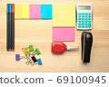 The top view of creative desk with office accessories, notebooks and colorful stickers. Wooden background with copy space for inscription. 69100945
