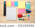 The top view of creative desk with office accessories, notebooks and colorful stickers. Wooden background with copy space for inscription. 69100946