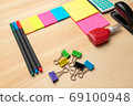 The top view of creative desk with office accessories, notebooks and colorful stickers. Wooden background with copy space for inscription. 69100948