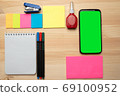 The top view of creative desk with office accessories, notebooks and colorful stickers. Wooden background with copy space for inscription. 69100952