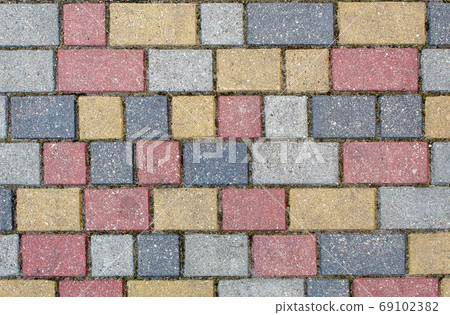 road paved with gray, yellow and brown sidewalk tiles. texture o 69102382