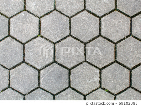 road paved with hexagonal sidewalk tiles. texture of light gray 69102383