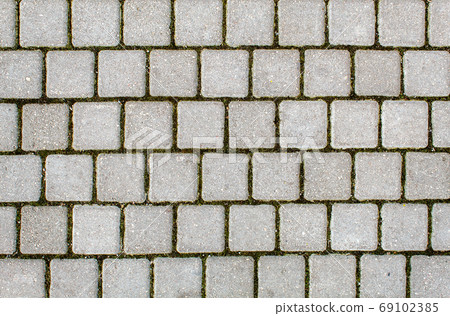 road paved with sidewalk tiles. texture of light gray bricks. road paved with sidewalk tiles. texture of light gray bricks. 69102385
