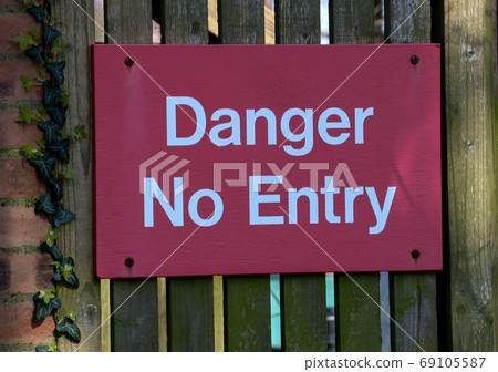 Danger No Entry Sign on an Old Perimeter Gate 69105587