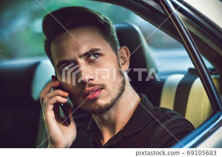Passenger businessman use a smartphone in the back Passenger businessman use a smartphone in the back 69105683