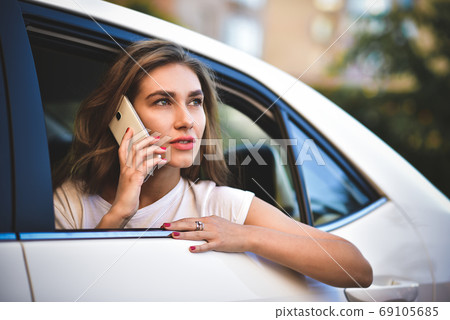 Attractive woman with phone in car Attractive woman with phone in car 69105685