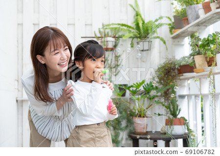母親和她的孩子在陽台上玩肥皂泡 母親和她的孩子在陽台上玩肥皂泡 69106782