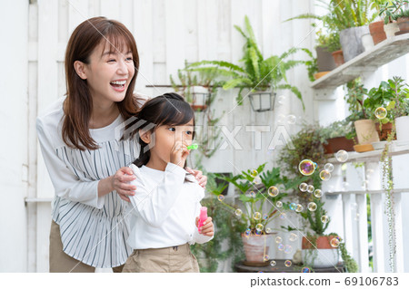 母親和她的孩子在陽台上玩肥皂泡 母親和她的孩子在陽台上玩肥皂泡 69106783