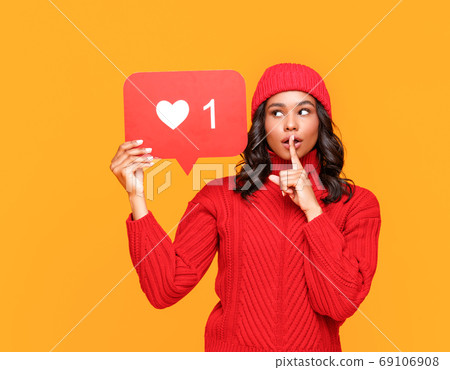 Ethnic woman sharing secret in social media. 69106908