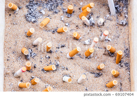 Many Cigarette butts discarded in ashtray Many Cigarette butts discarded in ashtray 69107404