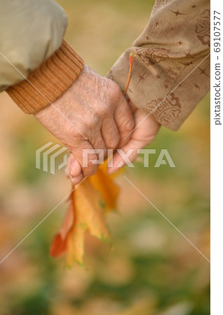 Couple holding hands together close-up on background 69107577
