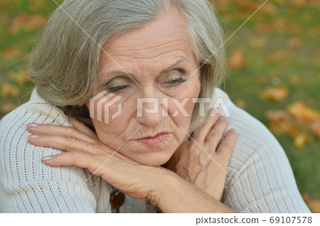 Portrait of sad, thoughtful senior woman in park Portrait of sad, thoughtful senior woman in park 69107578