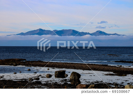 Isle of Arran Emerging from Low Cloud from Seamill Beach Scotlan Isle of Arran Emerging from Low Cloud from Seamill Beach Scotlan 69108667