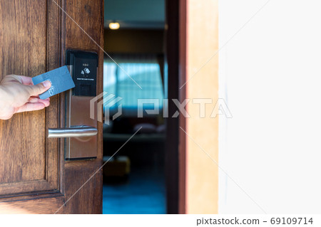 Smart card door key lock system in hotel. Hotel electronic lock on wooden door. 69109714