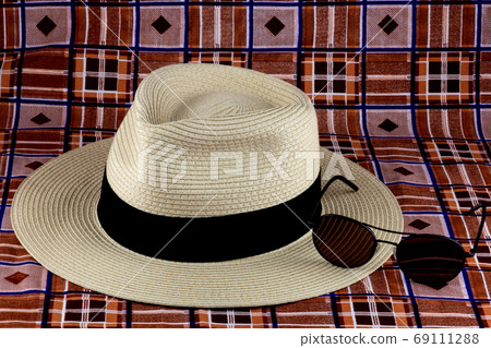 Panama Hat with Sunglasses on a Beach Sarong 69111288