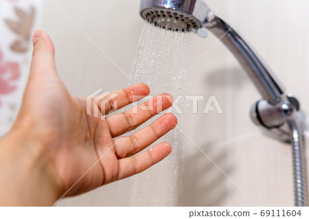 washing concept. Hygiene Man is checking a water temperature. 69111604