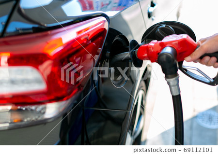 A man who refuels at a gas station 69112101