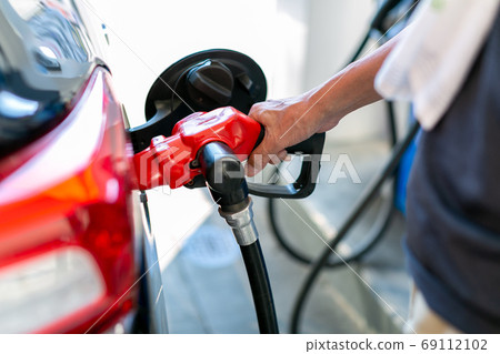 A man who refuels at a gas station 69112102