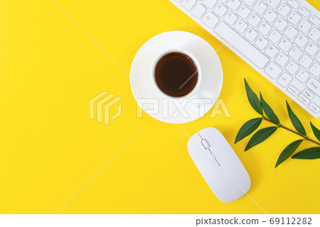 Office workplace with keyboard, computer mouse, cup of coffee and plant on yellow background Office workplace with keyboard, computer mouse, cup of coffee and plant on yellow background 69112282
