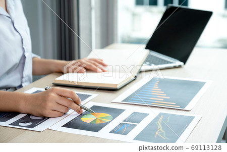 Businesswoman analysis the chart with laptop at the office 69113128