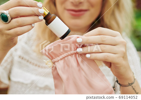 Woman packing rejuvenating essence Woman packing rejuvenating essence 69114052