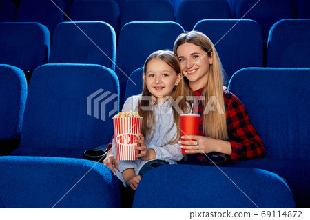 Mother spending time with daughter in cinema. Mother spending time with daughter in cinema. 69114872