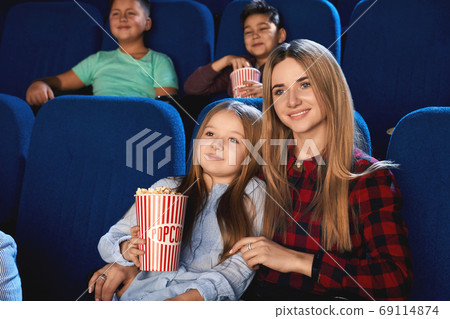 Mother hugging daughter in cinema. Mother hugging daughter in cinema. 69114874