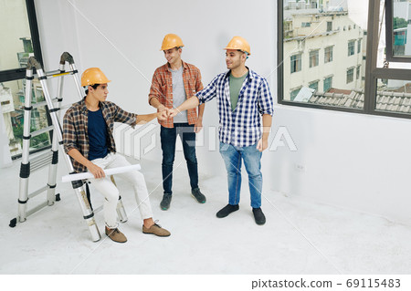 Engineers doing fists bump Engineers doing fists bump 69115483